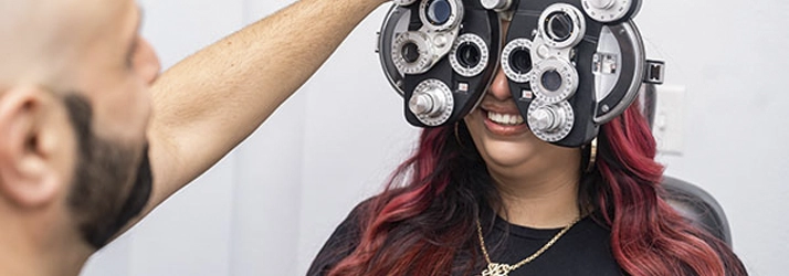 Close-up of Dr. Soroush Azadi adjusting the phoropter during a vision assessment in the exam room.